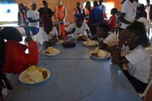 Volunteers serve lunch to children, during program