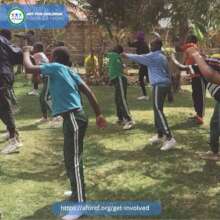 Children dancing guided by a volunteer