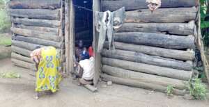 Resty Sweeping her compound as grand children cook