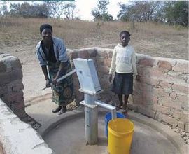 Irene and her daughter using the new borehole