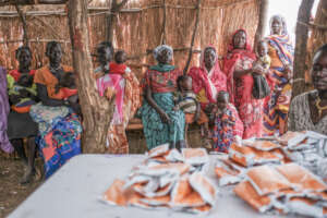 Mothers wait to register for food aid for children