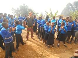 students and  volunteer HENRICK  at the assembly