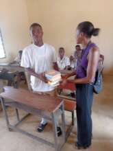 donor presents books to school affected by flood