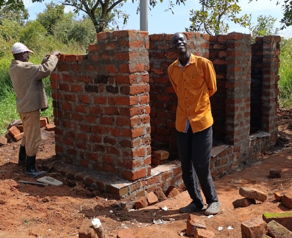 Happy Husband of Jennifer infront of new latrine