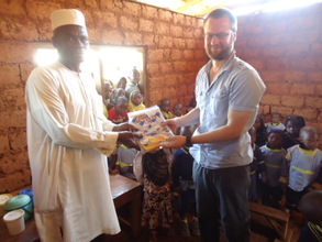 Volunteer handing gift to the School Head teacher