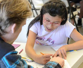 Child working with a volunteer
