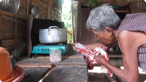 Her mother tinkers with the biogas-cooked lunch.