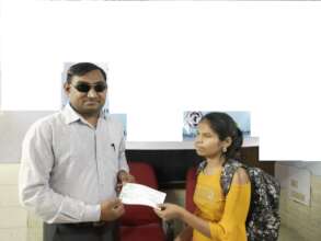 Rekha receiving a scholarship cheque
