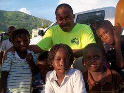 Father Dessalines helping children in the Artiboni