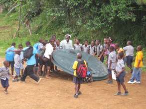 Children helping to install a 2000 gall water tank