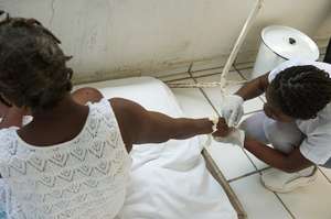 A nurse provides IV re-hydration for cholera pat.