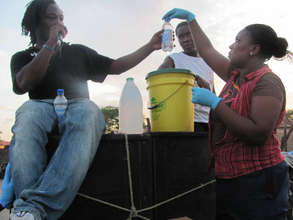 CHWs demonstrate water purification for a crowd