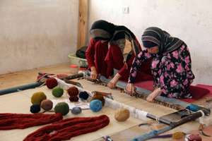 Women weaving a carpet