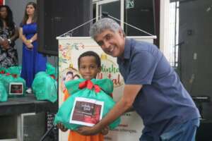 Sponsor giving a Christmas bag to student.