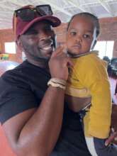 Mzi comforts a child.