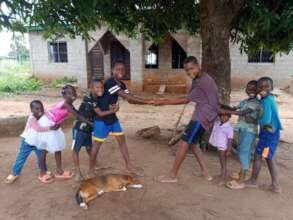 A group of smiling children playing tug-of-war