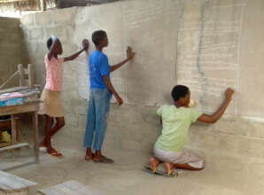 Small group tutoring, students work on chalkboard