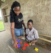 Edem helping Albert with his alphabet.