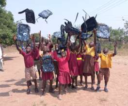 Students celebrating new backpacks from sponsors.
