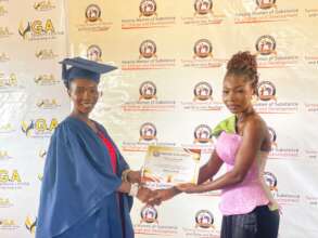 Melody receiving her certificate of completion