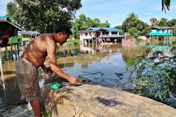 Resident repairs boat to get around flooded roads
