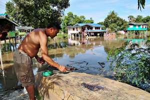 Resident repairs boat to get around flooded roads