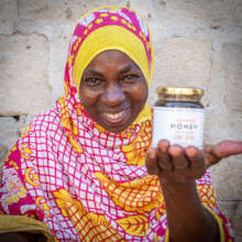 Beekeeper shows her jarred honey, Zanzibar
