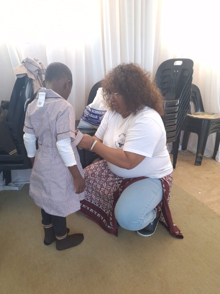 A Child Being Fitted With Her New Uniform