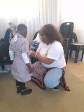 A Child Being Fitted With Her New Uniform