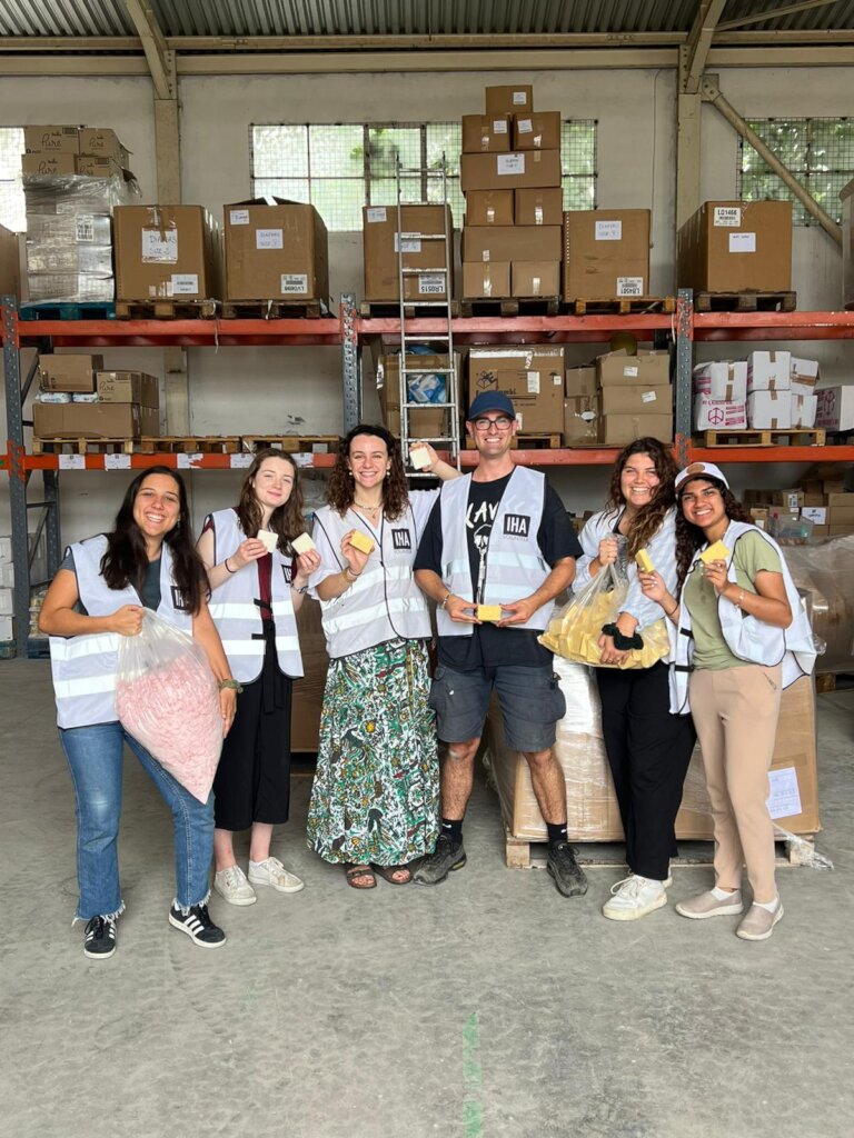 Volunteers at IHA in Greece hold up donated soap b