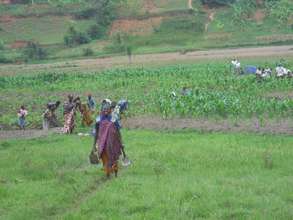 A happy Rwandan mom in front of her land