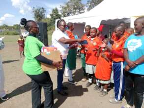 The ACC distributing books and pens to the pupils
