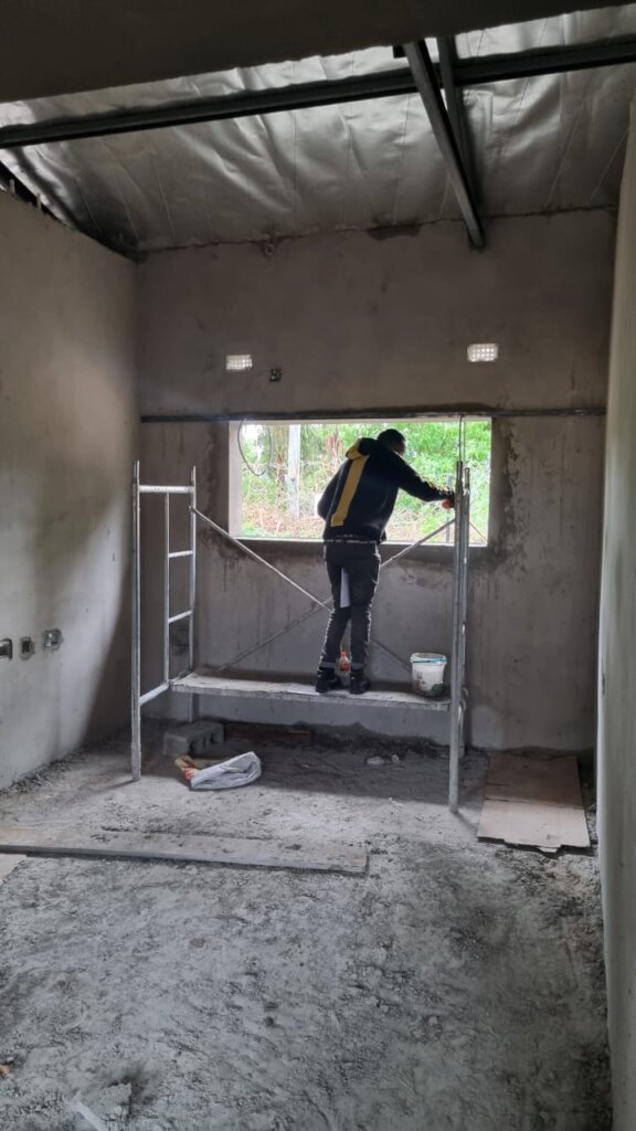 Contractor measuring for window installation