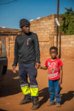 Thando and his dad walking towards school