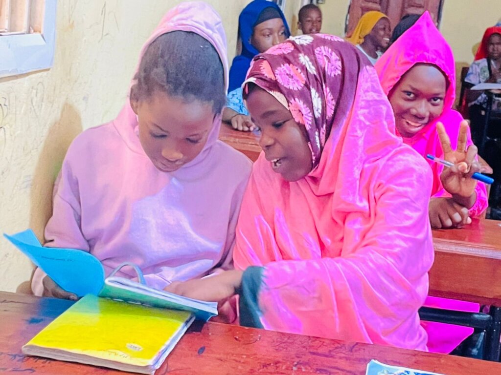 Girls help each other in class