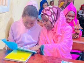 Girls help each other in class