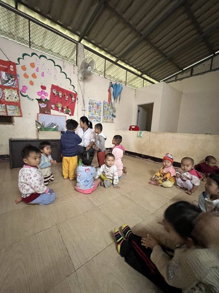 A teacher guides children to learn from books.