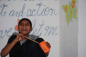 Farida helping to paint a mural in the classroom