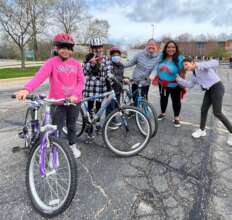 Maria (in pink) receives her bike after emigrating
