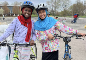 Two girls receive bikes for transport to school