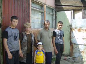 a family in front of "home" metal container