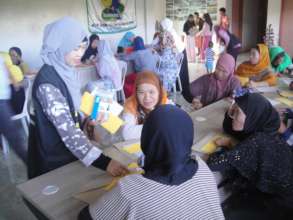 Volunteer Hameda (blue scarf) assisiting workshop