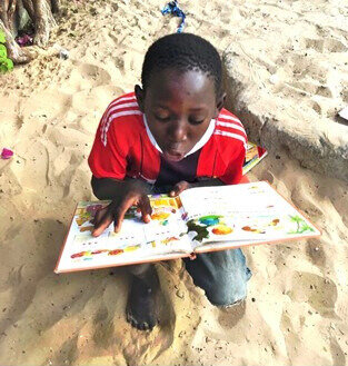 Talibe taking first steps reading at the centre