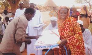 A woman receives a gas tank through microcredit.