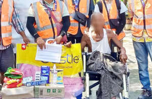 A man in a wheelchair receives relief supplies