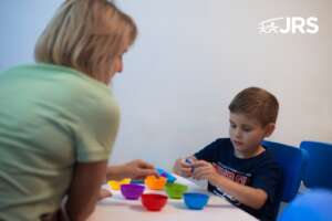 Boy engaging in a therapy game with colorful bowls