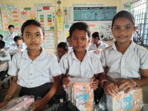 Smiling girls holding their newly kits.