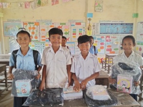 Smiling students holding their new school kits