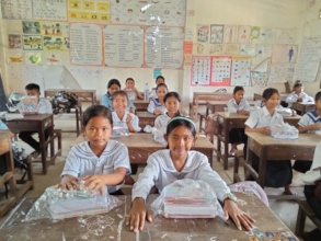 Students seated at tables with their newly kits.