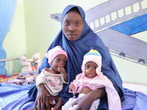 Mother with her twin babies receiving medical care